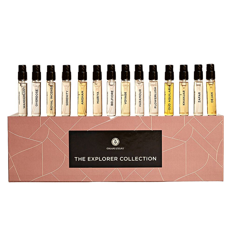 Set of 14 Omanluxury Explorer Collection 2.1 ml perfume vials, each in a small glass container with labels, arranged in a display.